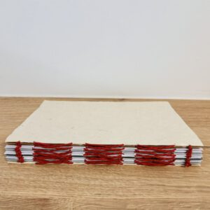 Rug van een handgebonden boekje met zichtbare rode steken